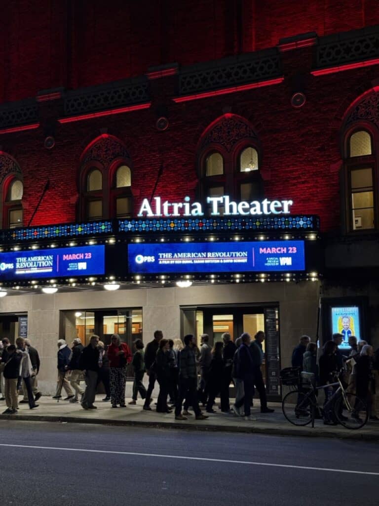 Altria Theater at night with people waiting outside, illuminated marquee, historic architecture, vib.
